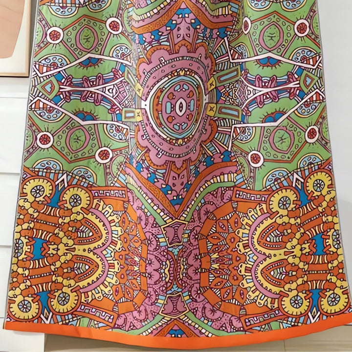 A colorful, patterned cotton gauze bath towel with a Moroccan-inspired design in shades of green, pink, orange, and yellow.