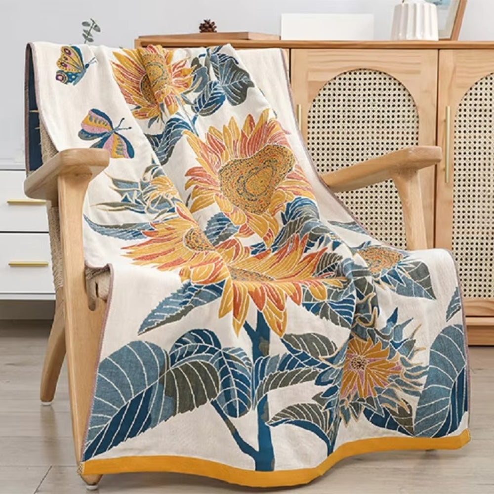 A cotton bath towel with a sunflower jacquard design draped over a wooden chair.