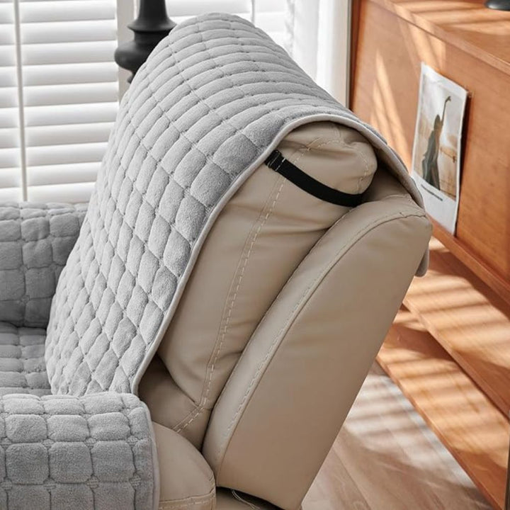 Gray quilted microfiber recliner chair cover draped over a tan leather recliner armrest.