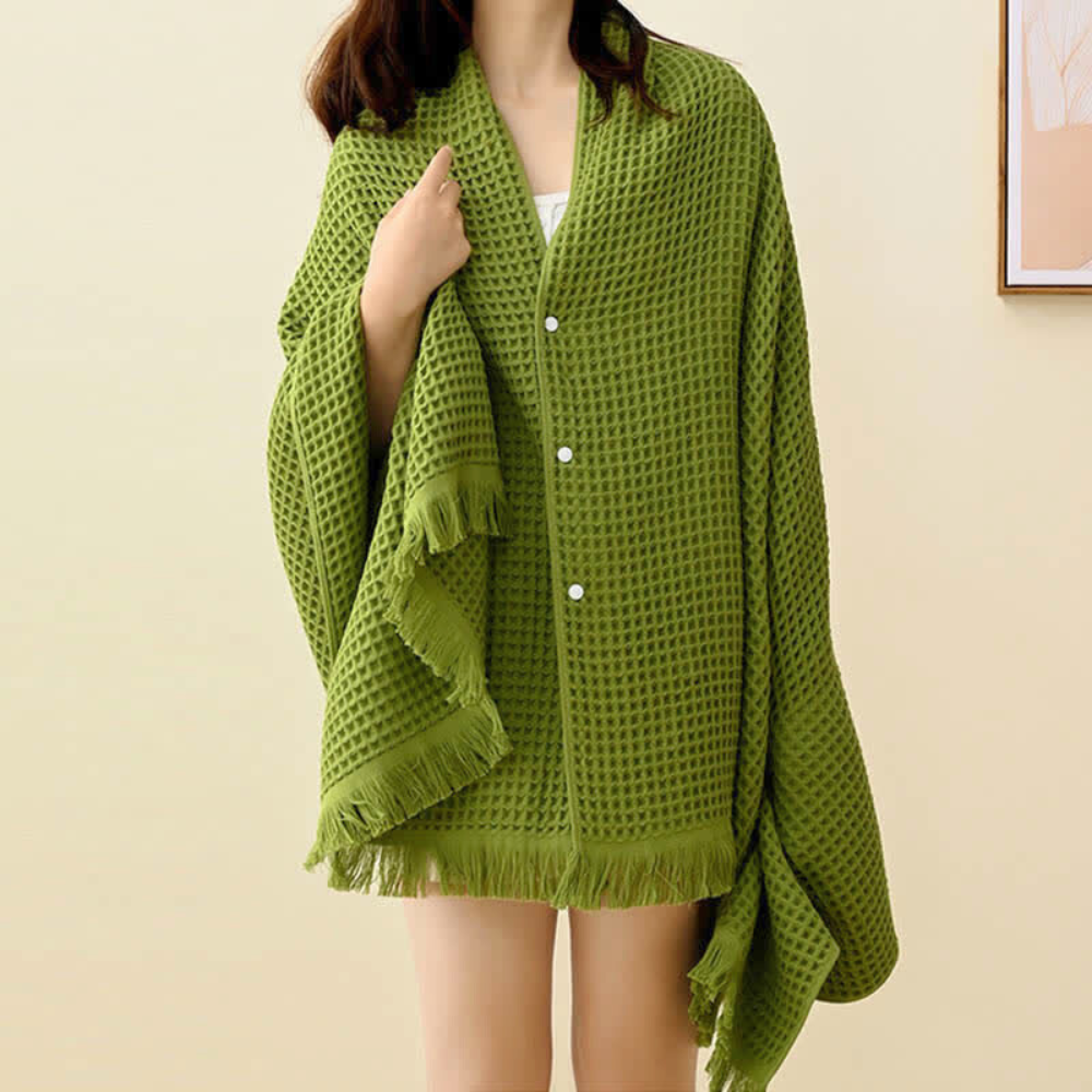 Green waffle weave cotton towel worn as a shawl by a person.