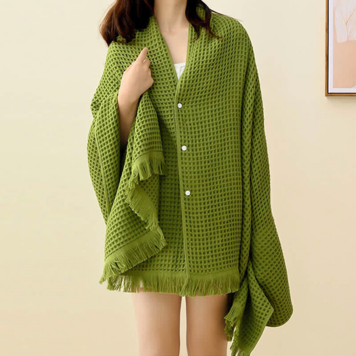 Green waffle weave cotton towel worn as a shawl by a person.