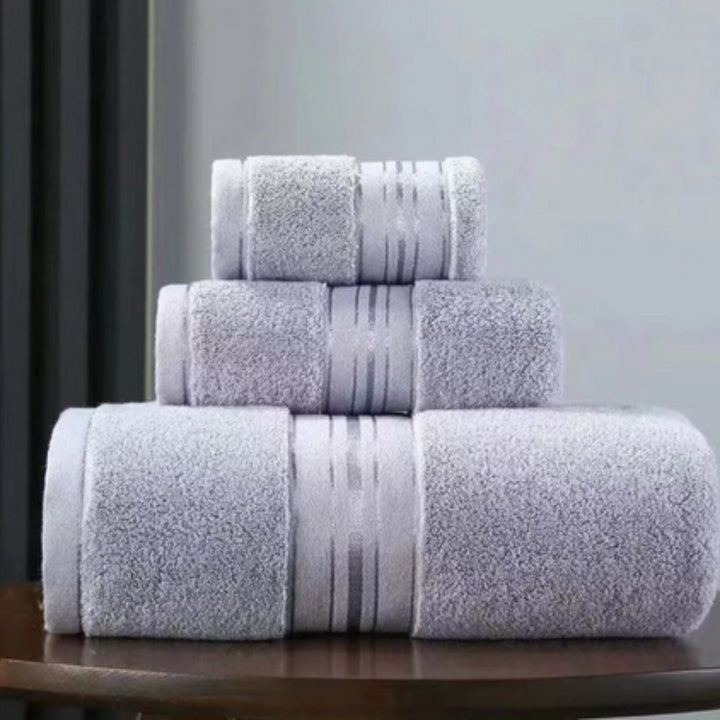 Stack of three light purple Egyptian cotton towels with a striped band.
