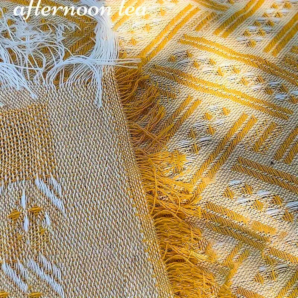 Yellow and white geometric pattern picnic mat with frayed edges.