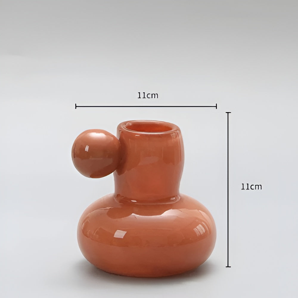 Orange glass candle holder with a round ball accent, 11cm wide and 11cm tall.