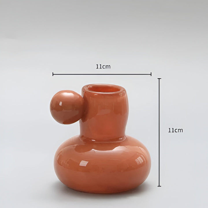 Orange glass candle holder with a round ball accent, 11cm wide and 11cm tall.