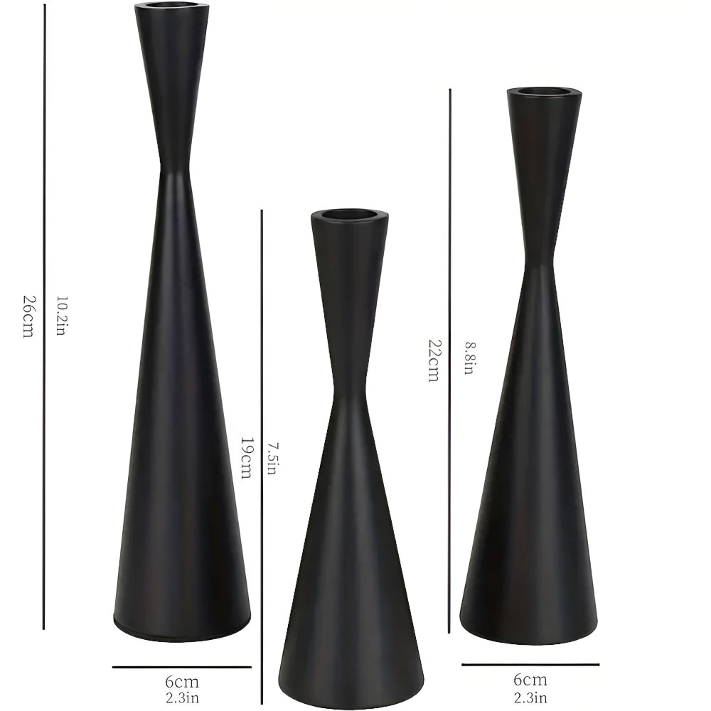 Set of three black iron candlesticks with a modern waist design and varied heights.