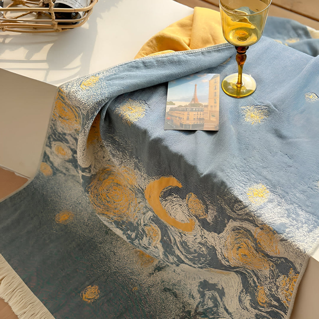 Blue cotton bath towel with a swirling starry night pattern and fringed edges.