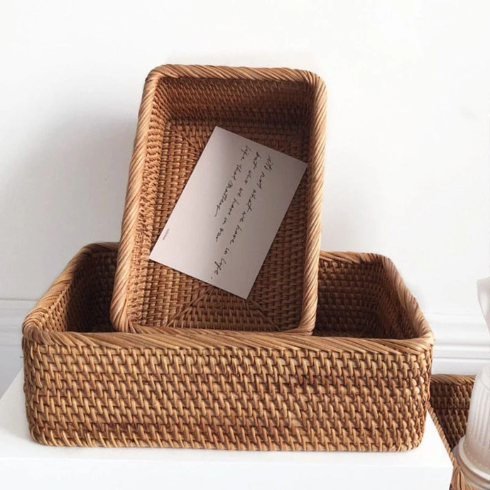 Two hand-woven rattan storage baskets, one nested inside the other, with a card inside the top basket.