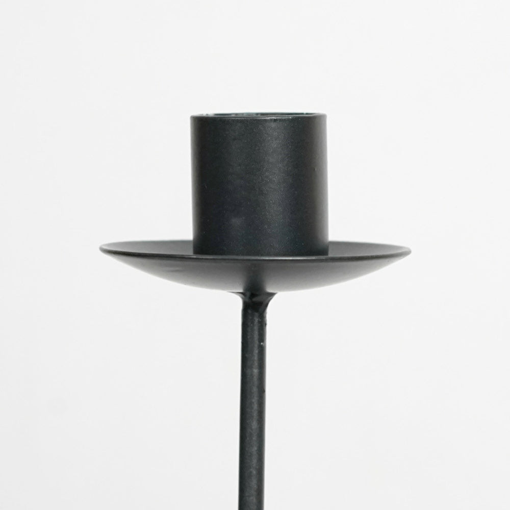 Black iron candle holder with a wide, flat base and a cylindrical top.