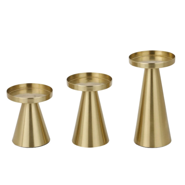 Set of three artisan brass candle holders in varying sizes on a white background.