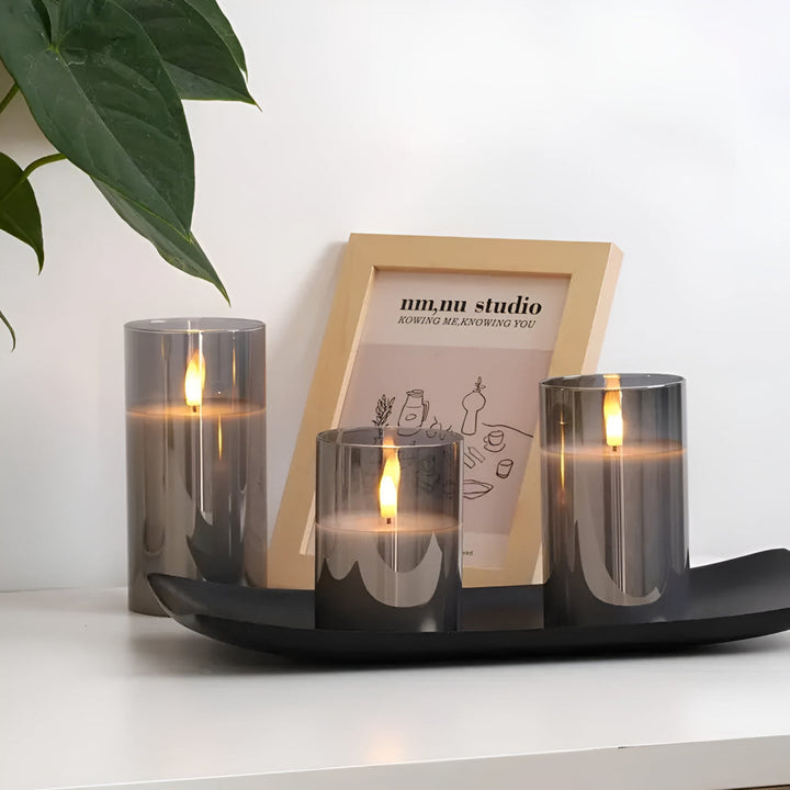 Three grey glass flameless candles with 3D LED flames on a black tray.