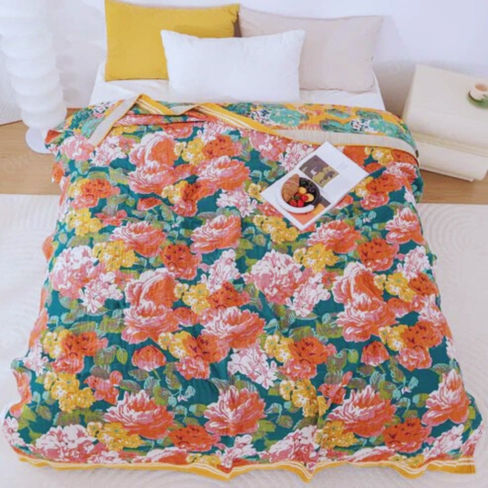 Tropical Breeze Cotton Blanket with a vibrant floral pattern in shades of orange, pink, yellow, and teal.