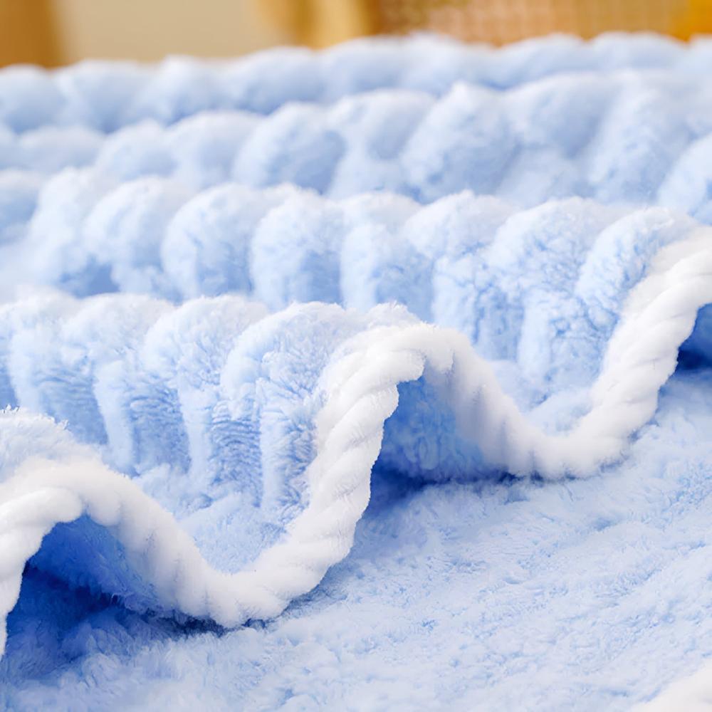 Close-up of a soft, light blue fleece towel with a white braided trim.