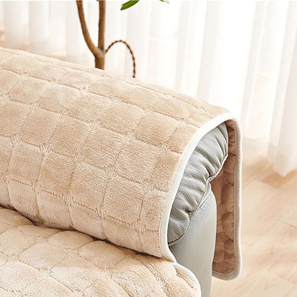 Beige quilted microfiber recliner chair cover draped over the armrest of a gray leather recliner.