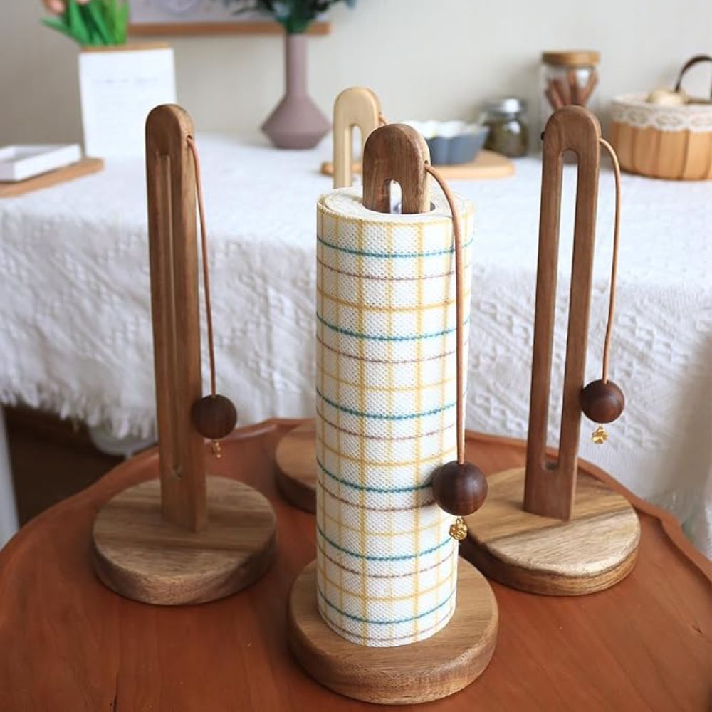 Acacia wood paper roll stand with a plaid paper towel and wooden balls.
