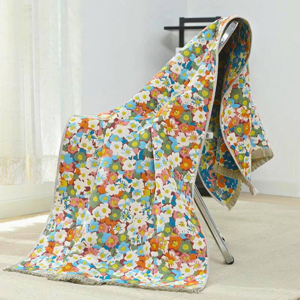Reversible cotton bath towel with a colorful floral pattern draped over a chair.
