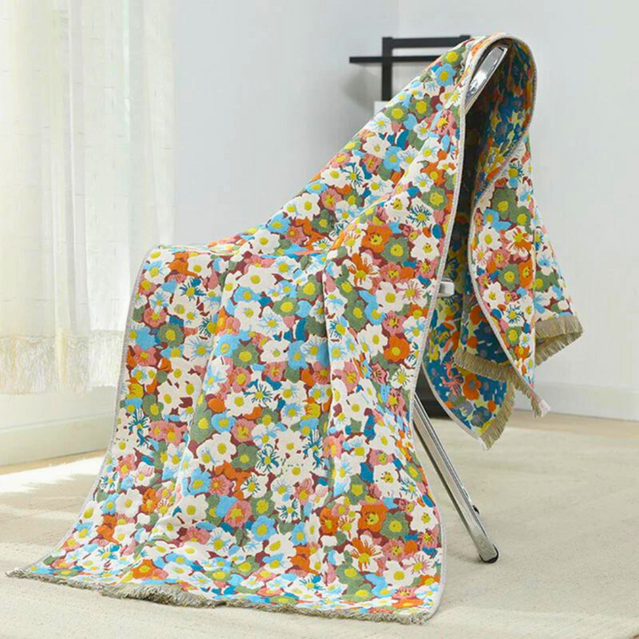 Reversible cotton bath towel with a colorful floral pattern draped over a chair.