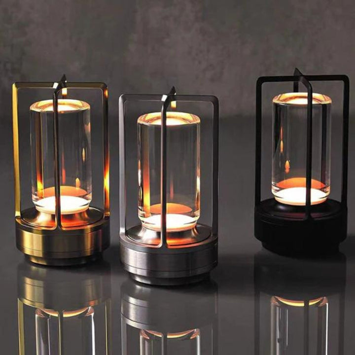 Three Nordic-style crystal table lanterns with warm ambient glow, in gold, silver, and black finishes.