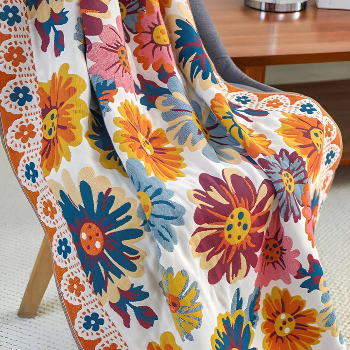 A throw blanket with a vibrant, multi-colored floral pattern draped over a chair.
