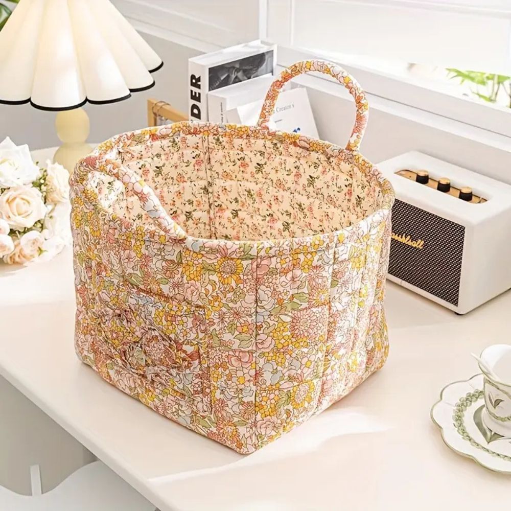 Quilted canvas storage basket with a delicate floral print and two handles.