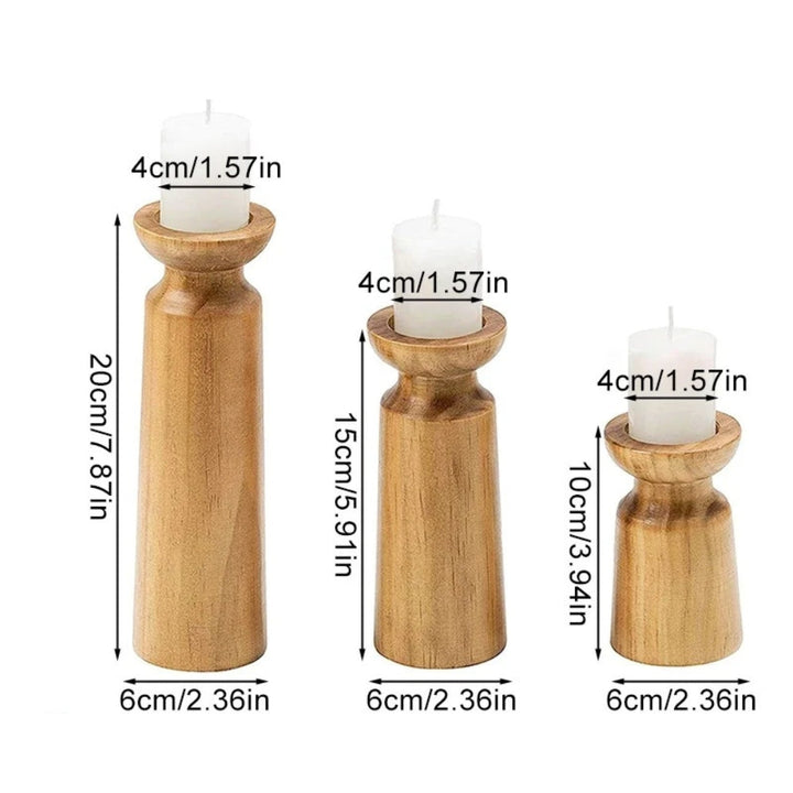 Set of three carved pine candle holders in varying heights, each holding a white candle.