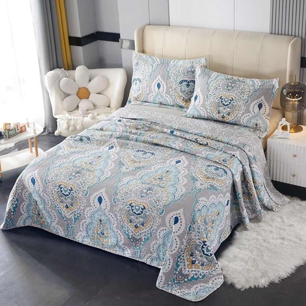 Paisley aqua teal coverlet set with two matching pillow shams on a bed.