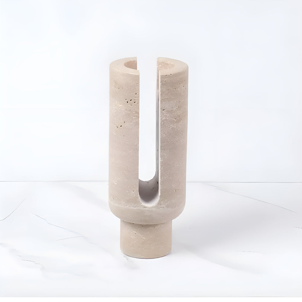 Sculptural beige marble candle holder with a U-shaped opening.