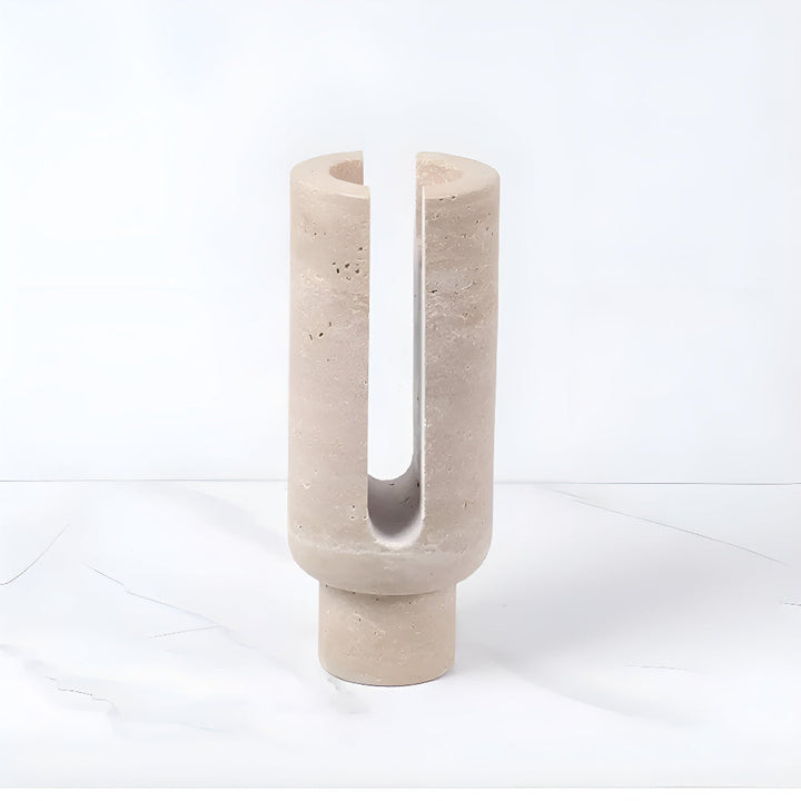 Sculptural beige marble candle holder with a U-shaped opening.