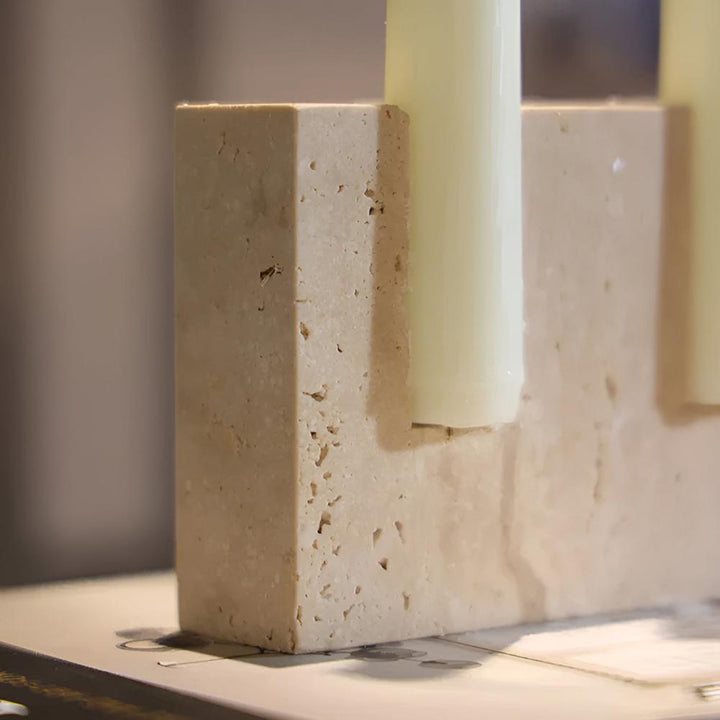 Travertine stone candle stand holding two taper candles.