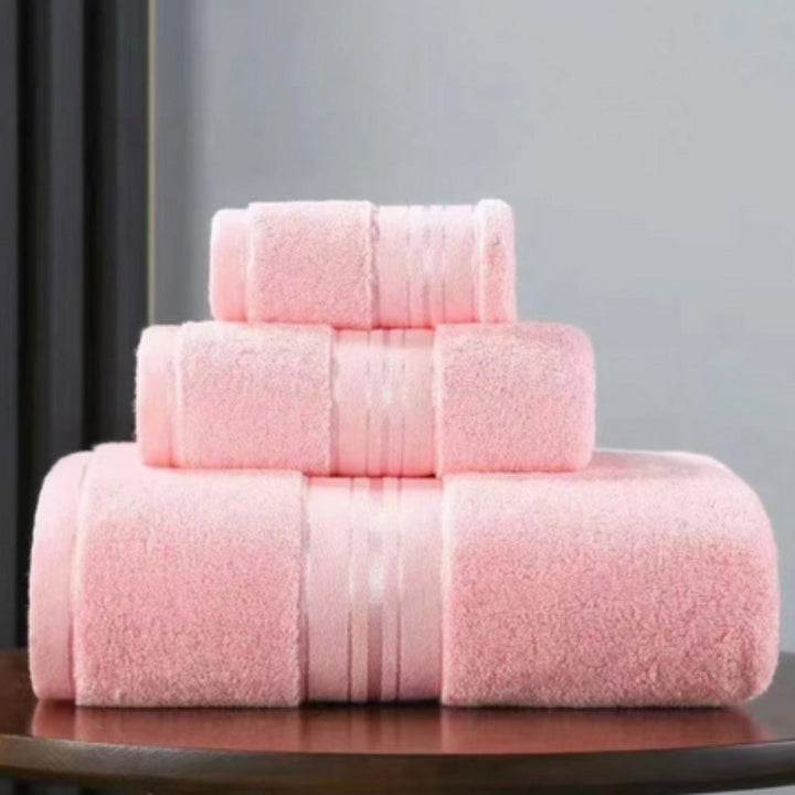 Three stacked pink Egyptian cotton towels of varying sizes.