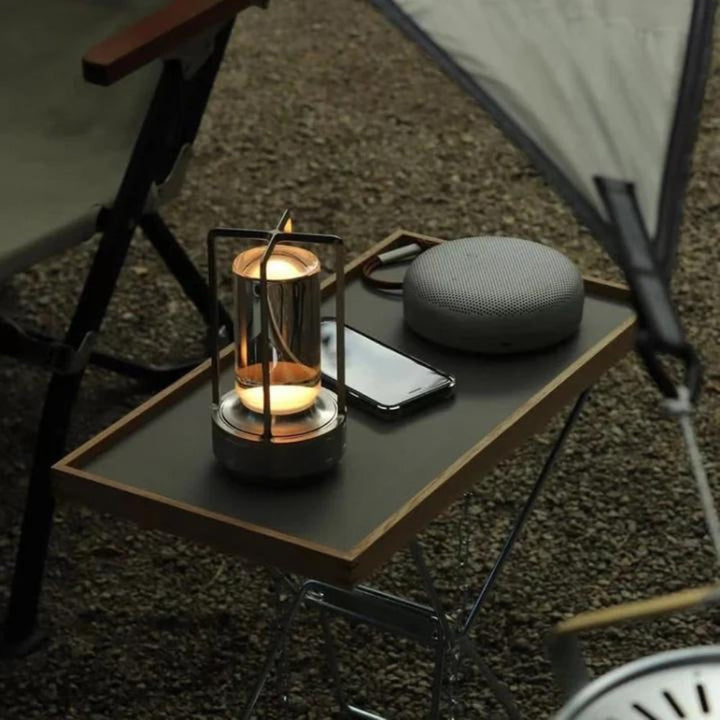 Crystal table lantern with warm ambient glow on a tray with a phone and speaker.