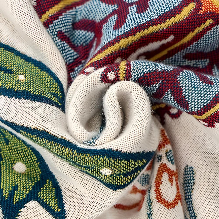 Close-up of a rolled cotton bath towel with a colorful floral pattern in red, yellow, blue, and green.