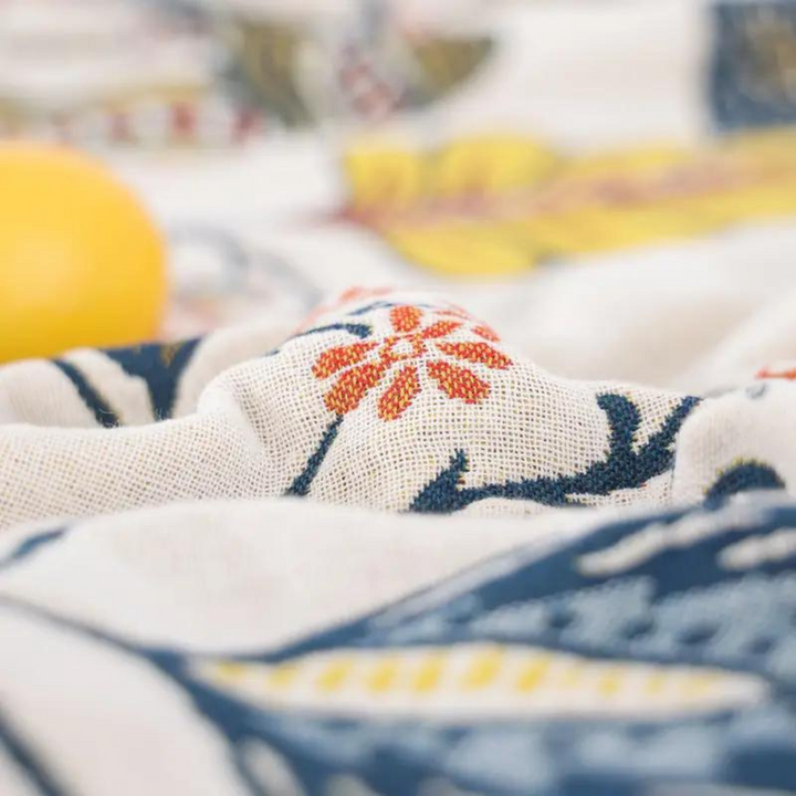 Close-up of a rustic artistic flora cotton blanket with a red and orange floral pattern.