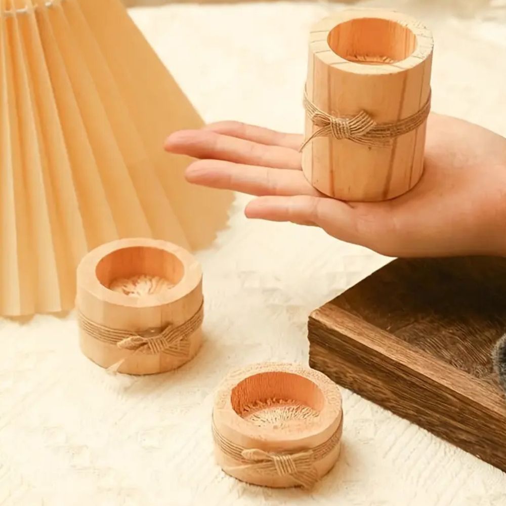 Three handcrafted bamboo candle holders with twine accents on a textured surface.