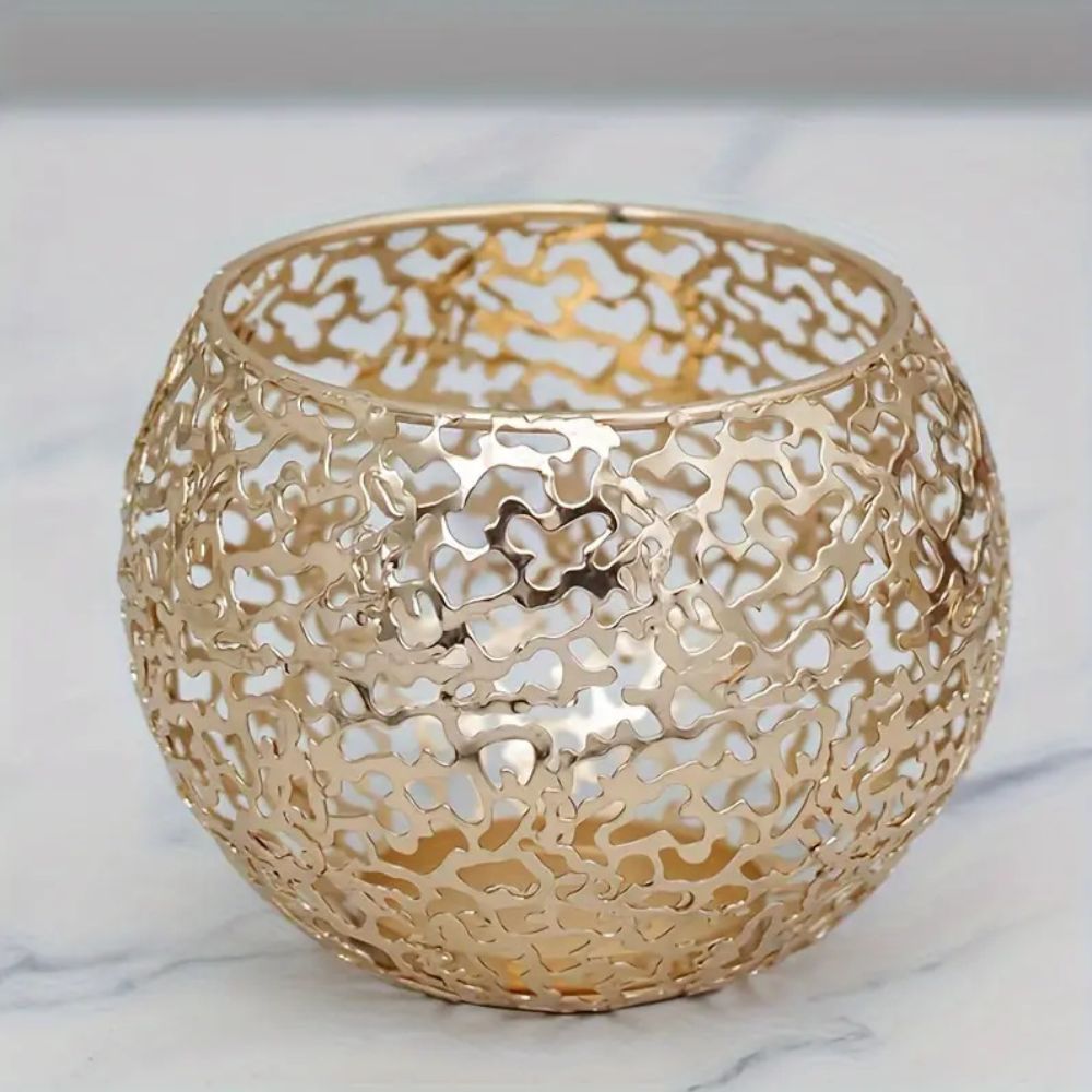 Gold geometric iron sphere tealight holder with a hollow, intricate design.