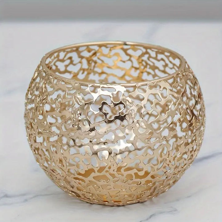 Gold geometric iron sphere tealight holder with a hollow, intricate design.