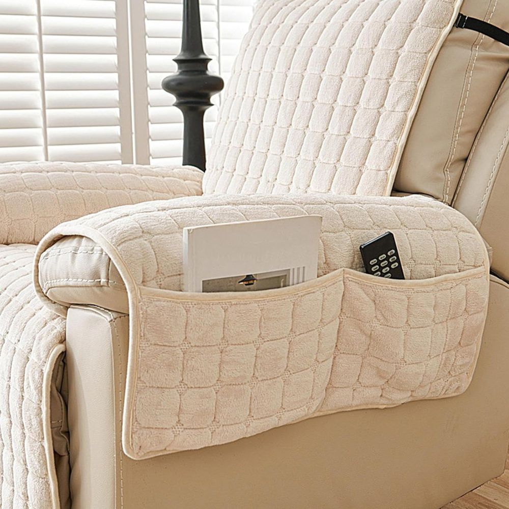Cream quilted recliner chair cover with side pockets holding a book and remote.