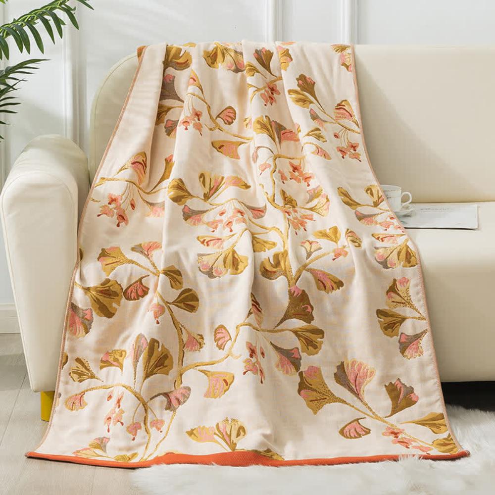 Beige cotton gauze bath towel with a ginkgo leaf print in pink and gold.