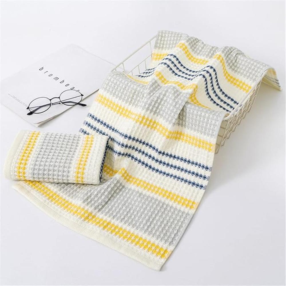 Colorblock striped cotton bath towel with honeycomb weave in a white basket.