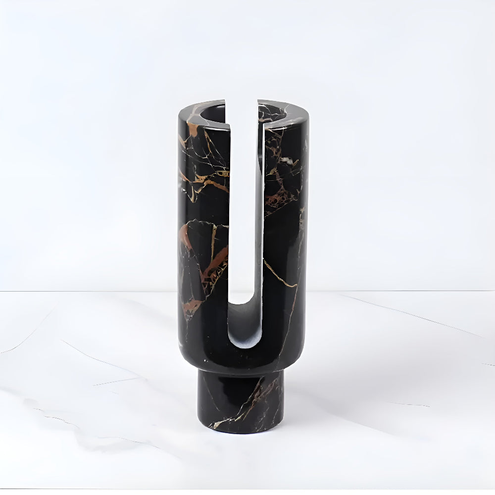 Black marble candle holder with gold veining and a U-shaped cutout.