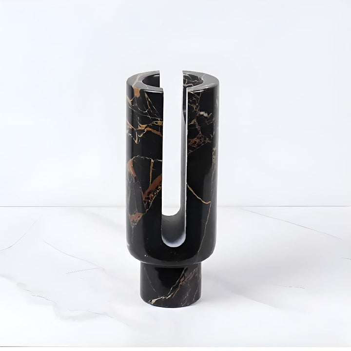 Black marble candle holder with gold veining and a U-shaped cutout.