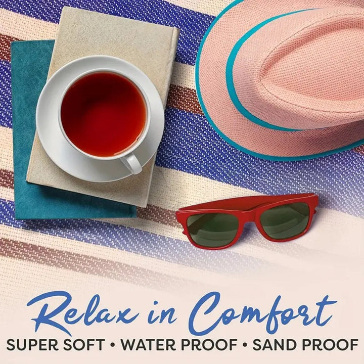 Waterproof picnic mat with a book, tea, hat, and sunglasses on a striped background.
