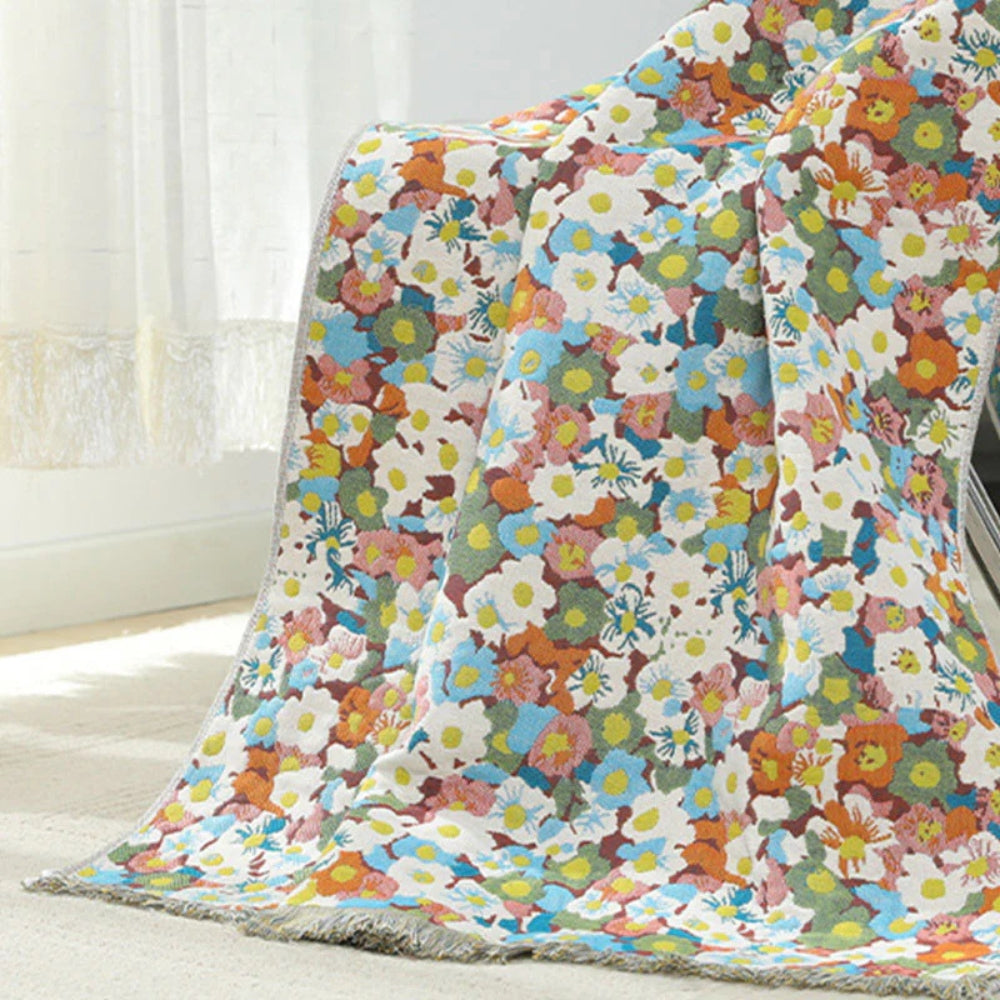 A colorful floral patterned cotton bath towel draped over a chair.