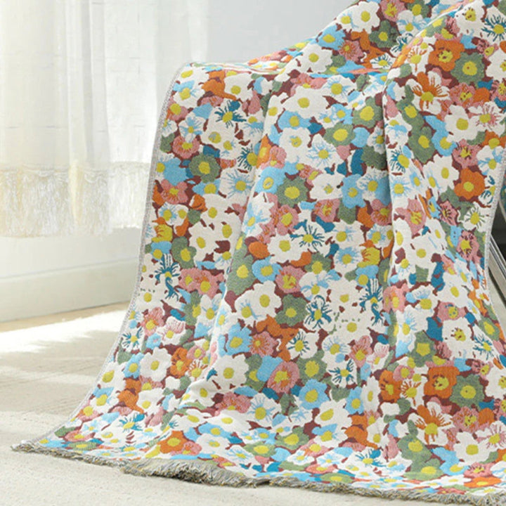 A colorful floral patterned cotton bath towel draped over a chair.