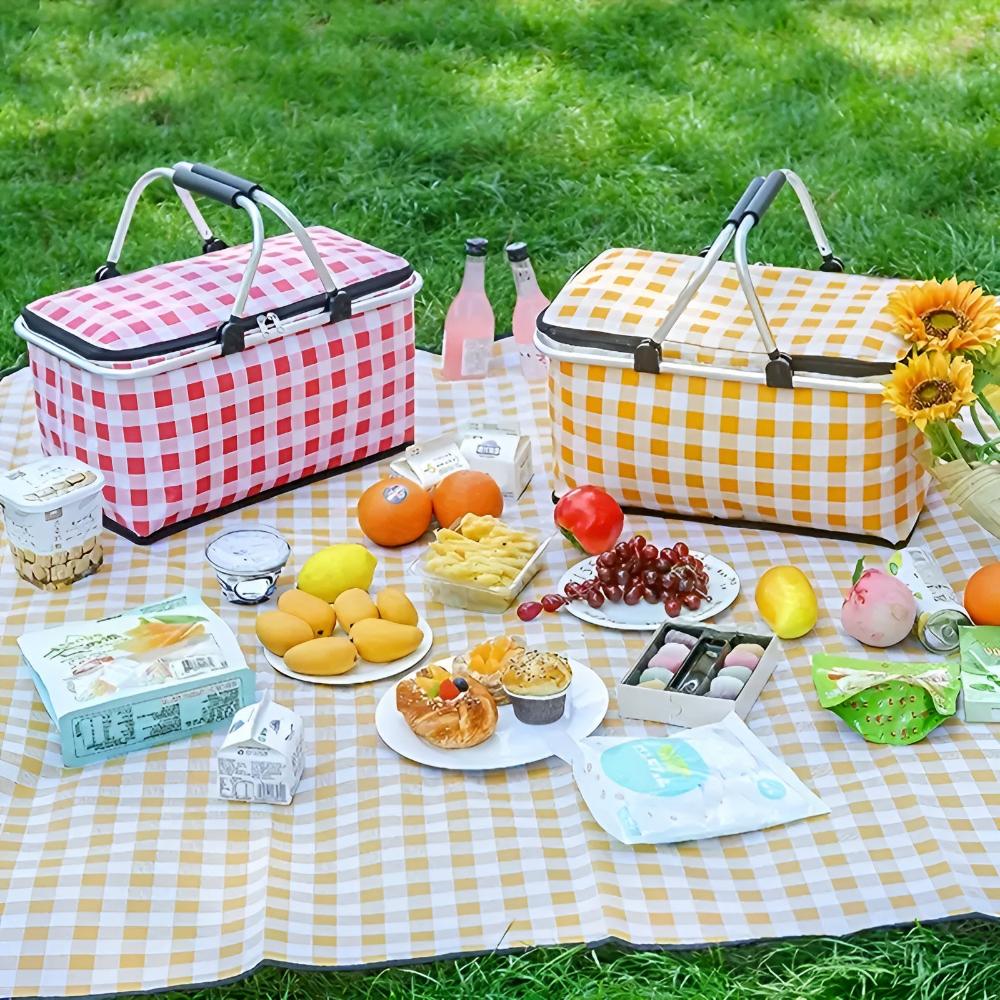Two checkered picnic baskets, one red and white, one yellow and white, filled with food and drinks on a picnic blanket.