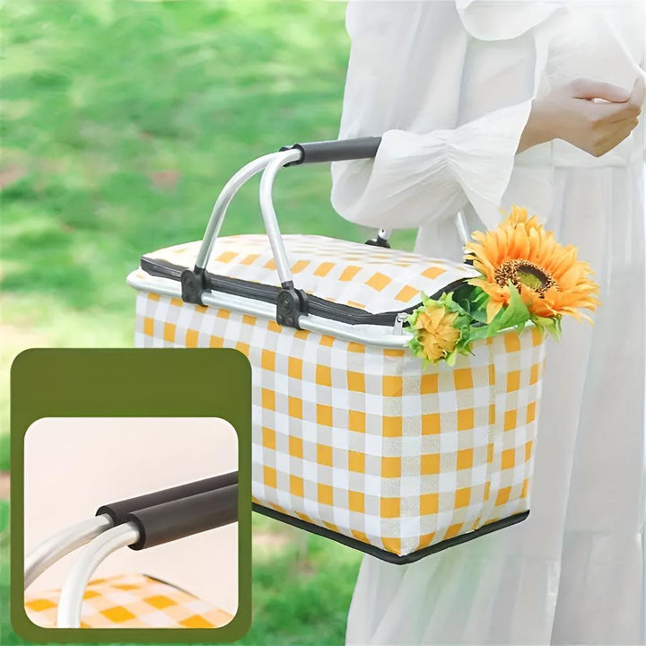 Yellow and white checkered picnic basket with a silver frame and black handles, holding sunflowers.