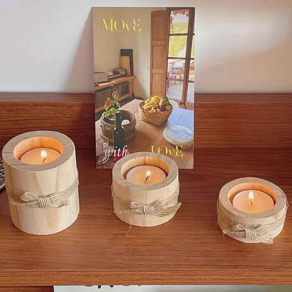 Three handcrafted bamboo candle holders with lit candles on a wooden shelf.