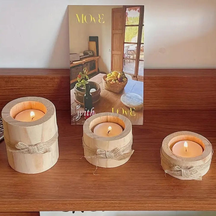 Three handcrafted bamboo candle holders with lit candles on a wooden shelf.