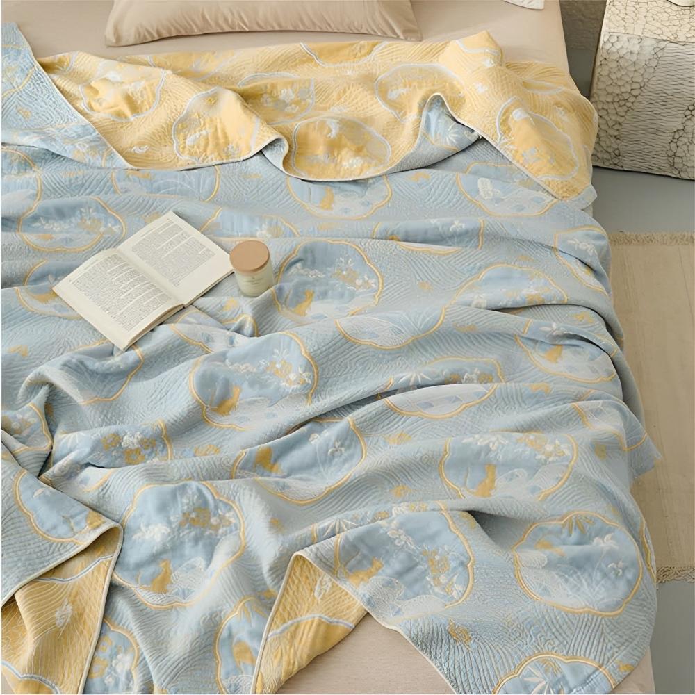 Reversible blanket with a blue side featuring a floral and animal pattern, and a yellow side.