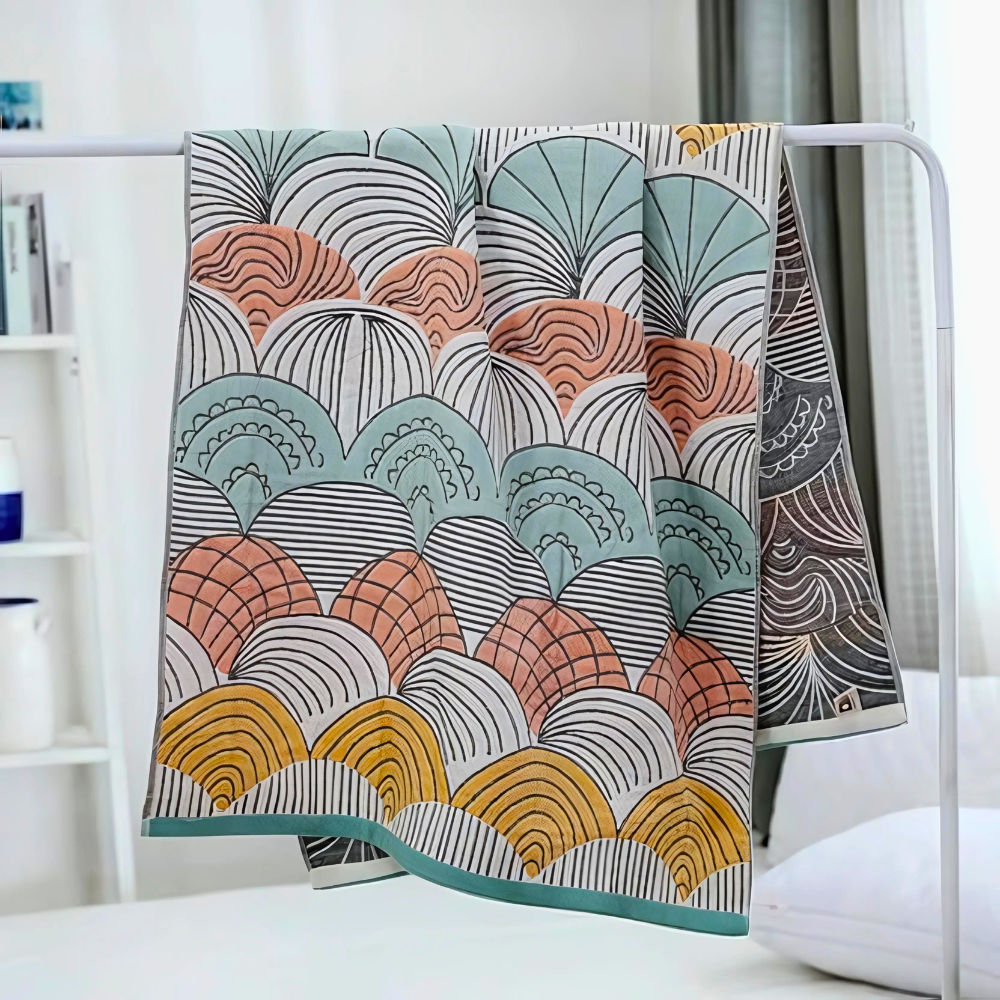 Cotton bath towel with a colorful abstract shell pattern in green, peach, yellow, and black.